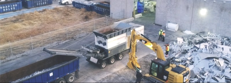 Digger filling truck up with metal scraps